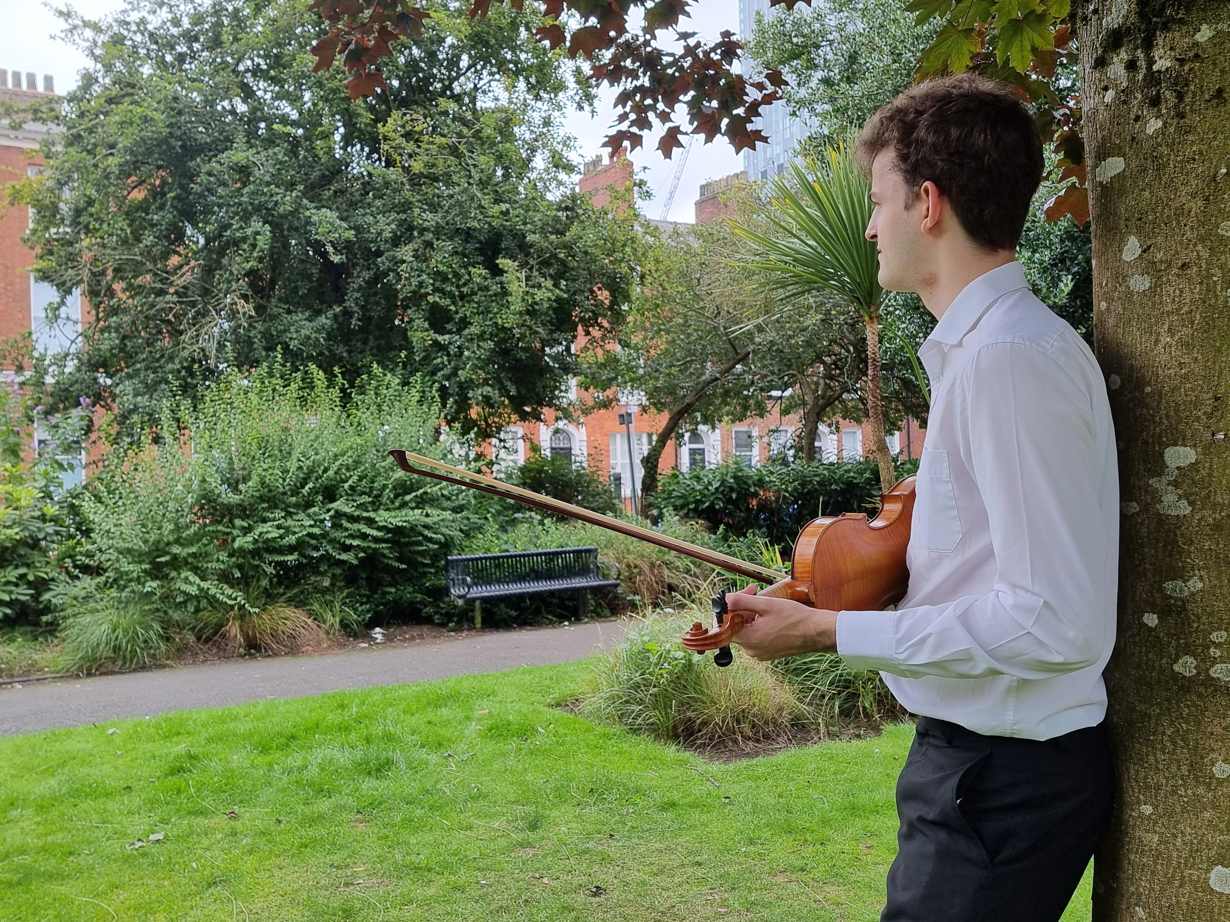 James in a park with his violin